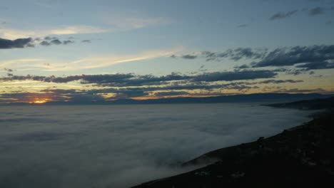 Luftaufnahme-über-Dem-Nebelmeer,-Das-Den-Genfersee-Bei-Sonnenuntergang-Lavaux-–-Schweiz-Bedeckt