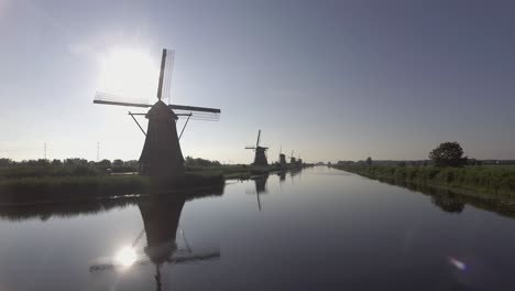 A-drone-shot-panning-left,-around-Dutch-Windmills-during-sunrise