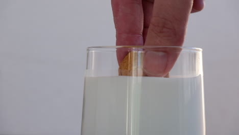 Zeitlupenaufnahmen-Eines-Kekses,-Der-Vor-Einem-Isolierten-Hintergrund-In-Ein-Glas-Milch-Getaucht-Wird