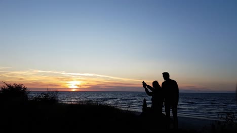Junges-Paar-Beobachtet-Den-Sonnenuntergang-Am-Strand