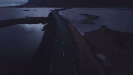 Drohnenaufnahme-In-Den-Westfjorden-Islands,-Die-Entlang-Einer-Straße-In-Die-Landschaft-Fliegt