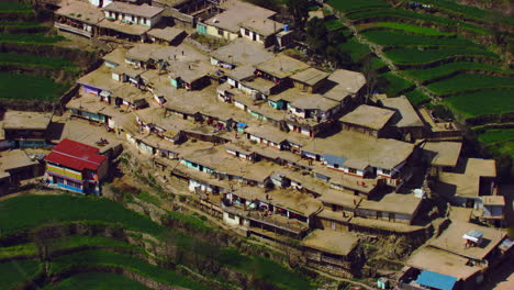 Un-Pueblo-En-La-Esquina-De-La-Montaña,-La-Gente-Camina,-Los-Techos-De-Las-Casas,-La-Vista-Aérea