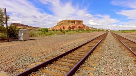 Rail-road-tracks-of-into-the-distance-in-the-Arizona-desert-blue-skies-and-puffy-white-clouds