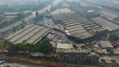 A-factory-top-view-with-a-busy-road-of-Bombay,-India,-sun-light-on-the-roof-of-the-factory