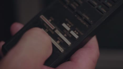 Closeup-of-a-finger-pressing-the-play-button-on-a-old-remote-TV-control