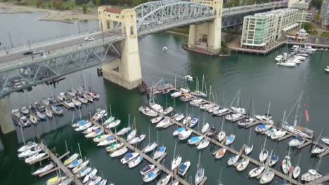 4k-Aerial-Shot-of-Boat-Club-with-Sailboats-and-Going-to-Bridge-with-Traffic-in-Vancouver,-Canada