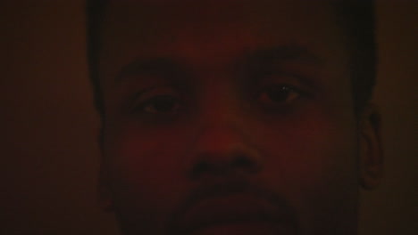 Close-up-of-African-American-mans-face-while-still-with-flashing-colorful-lights