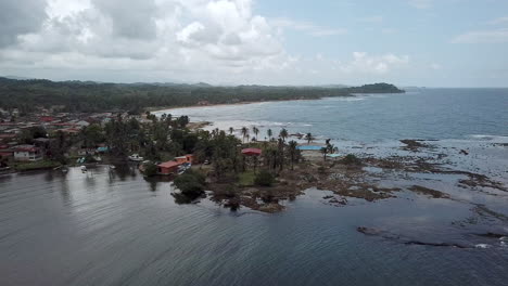 Aerial-shot-of-small-caribbean-town-by-the-sea-paning-left,-Palenque,-Colon,-Panama