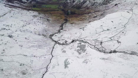 Aerial-footage-of-a-snow-covered-valley-in-Snowdonia-looking-towards-Llyn-Gwynant-and-Nant-Gwynant,-Wales