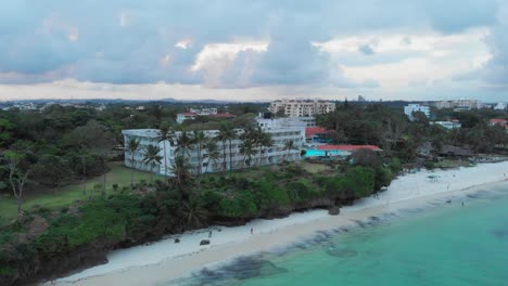Playa-De-Mombasa-Durante-Una-Puesta-De-Sol-Nublada,-Con-Resorts-Al-Fondo