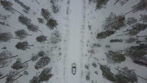 Cars-driving-through-a-snow-covered-landscape-near-Kuusamo,-Finland