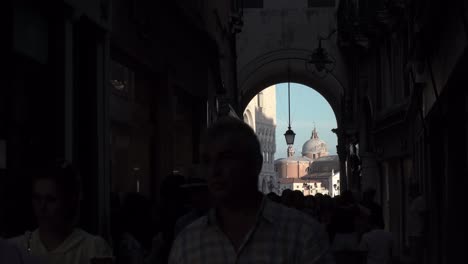 Los-Turistas-Caminan-A-Través-De-Un-Edificio-Con-Una-Hermosa-Arquitectura-De-Arco-En-Venecia,-Italia