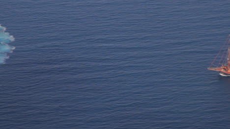 Ein-Touristisches-Ausflugsboot,-Das-Von-Den-Hohen-Klippen-Der-Insel-Santorini-Aus-Gesehen-Wird