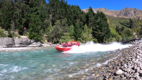 Shotover-Jet-Boat-speeding-by-in-slow-motion-in-Queenstown,-New-Zealand