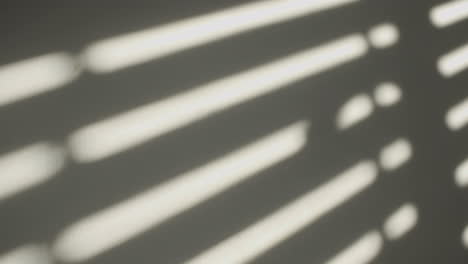 Close-Up-of-window-shutters'-shadow-on-a-wall-in-the-morning-sun