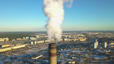 Aerial-orbital-shot-around-a-heavily-polluting-factory-chimney,-as-white-smoke-arise-in-a-Post-Soviet-country
