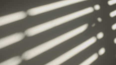 Shadows-on-the-wall-of-an-electric-window-shutter-being-opened-in-room