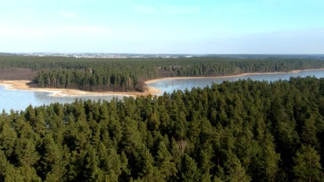 Eine-Vergrößerte-Luftaufnahme-Eines-Riesigen-Zugefrorenen-Sees-Und-Eines-Ausgedehnten-Waldes-Während-Der-Wintersaison-In-Polen