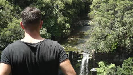 Young-caucasian-man-from-behind-looking-at-Mokoroa-Falls,-Auckland,-New-Zealand
