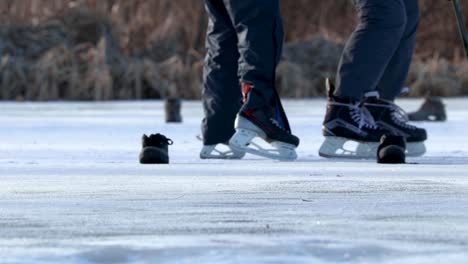 Eine-Statische-Nahaufnahme-Von-Menschen,-Die-Mit-Hockeyschlägern-Auf-Dem-Eis-Schlittschuh-Laufen