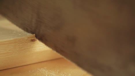 A-Macro-shot-of-a-carpenter-cutting-a-piece-of-Timber-with-a-Tenon-Saw-in-a-Furniture-Workshop-in-slow-motion
