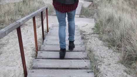Hipster-man-walking-down-the-stairs-in-the-dunes