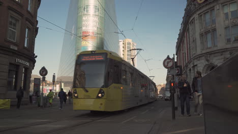Metrolink-tram-passes-by-outside-the-National-football-museum-in-Manchester