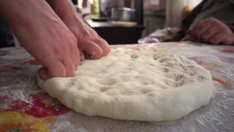 Woman-bare-hands-making-dough-to-a-flat-georgian-bread,-close-up