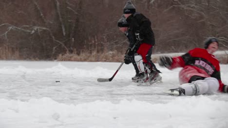 A-couple-children-are-playing-in-the-snow-and-on-the-ice-practicing-their-pond-hockey-skills