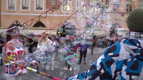 Male-street-performer-making-soap-bubbles-at-main-square-in-Prague,-Czechia