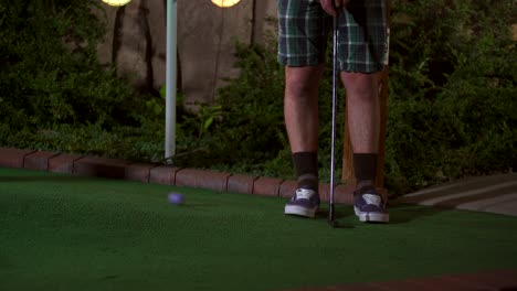 A-close-up-of-a-purple-mini-golf-ball-getting-hit-with-a-club-and-the-shot-is-horrible