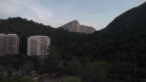 Sunrise-aerial-approach-and-panning-up-showing-the-Corcovado-mountain-in-Rio-de-Janeiro-behind-a-mountain-range-from-elsewhere-in-the-city-revealing-the-city-below