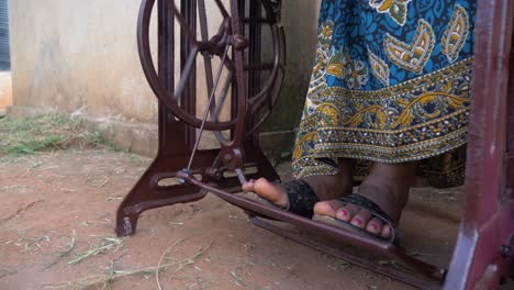 Eine-Nahaufnahme-Der-Füße-Einer-Afrikanischen-Frau,-Während-Sie-In-Afrika-Eine-Manuell-Bewegte-Schneidermaschine-In-Die-Pedale-Tritt