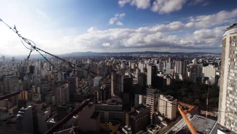 Panning-wide-view-of-the-city-skyline-of-São-Paulo-seen-from-the-Copan-building-on-a-sunny-day-with-blue-sky-and-clouds