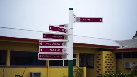 Multiple-golf-course-signs-pointing-different-directions-with-slow-motion-rain