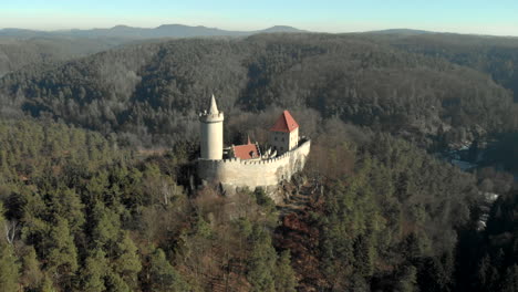 Eine-Epische-Luftaufnahme,-Die-Das-Berühmte-Tschechische-Wahrzeichen-Der-Burg-Kokorin-Umkreist,-Die-Sich-Aus-Dem-Umliegenden-Wald-Erhebt