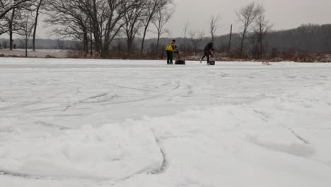 Ein-Paar-Erwachsene-Reinigen-Den-Schnee-Mit-Schaufeln-Vom-Teichhockeyfeld
