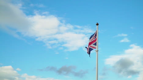 Tattered-Union-Jack-Flag-Blowing-in-Slow-Motion-Against-Blue-Sky