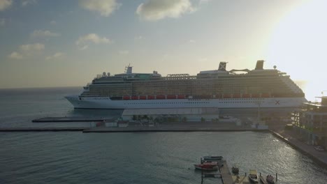 Aerial-view-of-a-big-cruise-ship-leaving-the-dock-on-a-sunny-day-4K