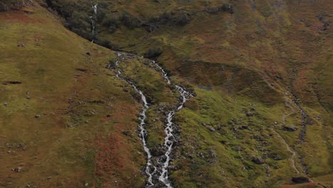 Luftabzug-Von-Einem-Fluss,-Der-Einen-Schottischen-Hügel-Im-Hochland-Von-Glencoe,-Schottland,-Hinunterrauscht