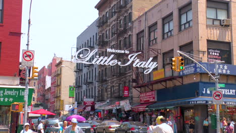 Timelapse,-Street-scene-in-Little-Italy,-Manhattan,-people-walking-and-crossing-roads-with-traffic-and-Little-Italy-sign