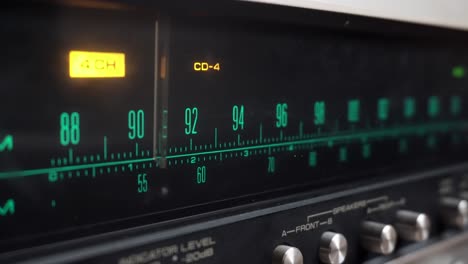 Tuning-in-an-old-and-retro-amplifier,-with-green-FM-numbers