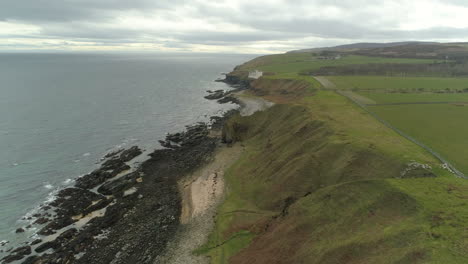 Aerial-view-moving-across-the-headland-heading-from-Dunbeath-towards-Dunbeath-Castle,-Caithness,-Scotland