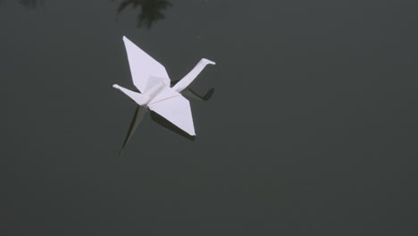 Closeup-of-origami-swan-floating-on-water-surface