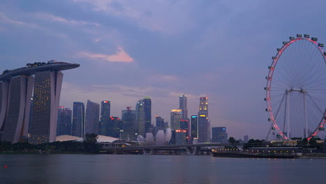 Singapur---Alrededor-Del-Lapso-De-Tiempo-Del-Día-A-La-Noche-Del-Horizonte-De-Singapur-Con-El-Volante-De-Singapur-Y-El-Hotel-Marina-Bay-Sands