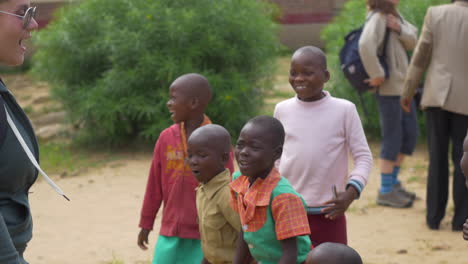 Ein-Amerikanischer-Besucher-Bringt-Simbabwischen-Schulkindern-Bei,-Wie-Man-An-Einem-Sonnigen-Tag-Draußen-Tanzt,-Mit-Rotierender-Steadycam-Bewegung