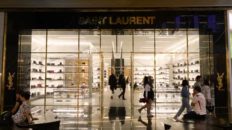 People-passing-in-front-of-Yves-saint-Laurent-store-in-Luxury-Icon-Siam-shopping-mall,-Bangkok