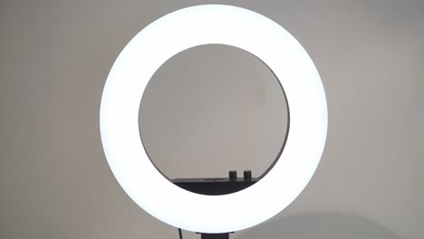 Turning-on-white-led-ring-lamp-in-the-studio