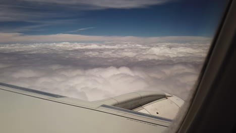 Subjektive-Sicht-Eines-Passagiers-In-Einem-Flugzeug,-Der-über-Einer-Dicken-Schicht-Weißer-Wolken-Unter-Blauem-Himmel-Fliegt