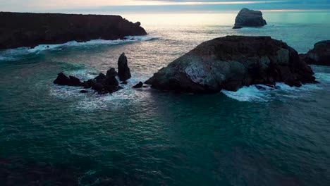 Flying-between-huge-ocean-rocks-close-to-crashing-waves-into-the-setting-sun-at-Sand-Dollar-Beach-in-Big-Sur-California